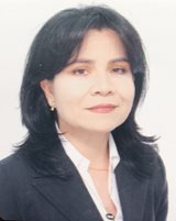 A Colombian woman with black hair in a white shirt and black jacket is shown against an off-white background.